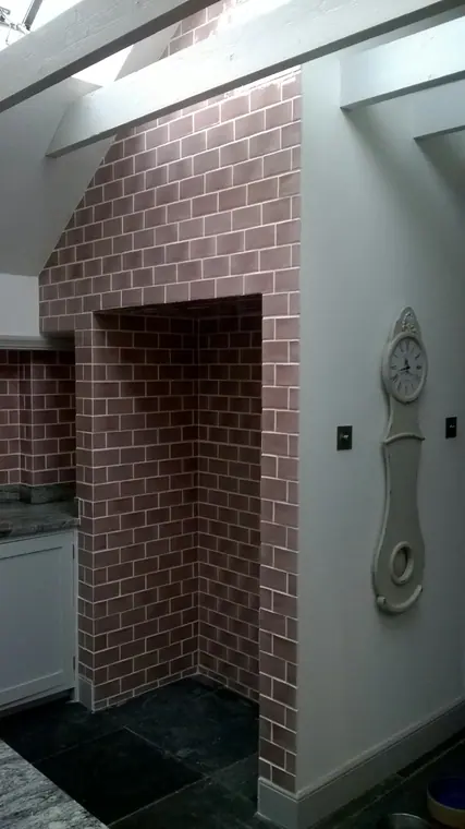 The tiled chimney breast rising towards the roof light, with the alcove below.