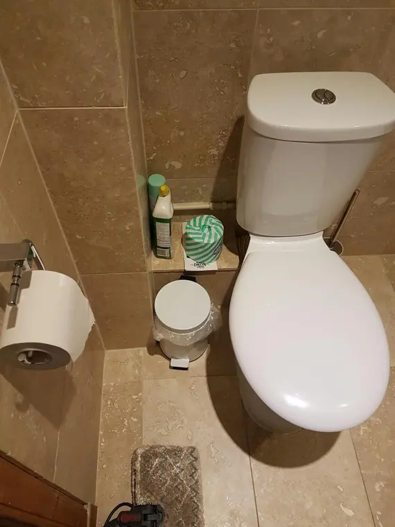 A cloakroom WC tiled in the same stone-effect finish.
