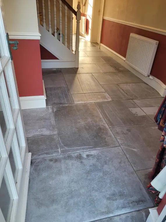 The tiled floor carried round the foot of the stairs and under the radiator.