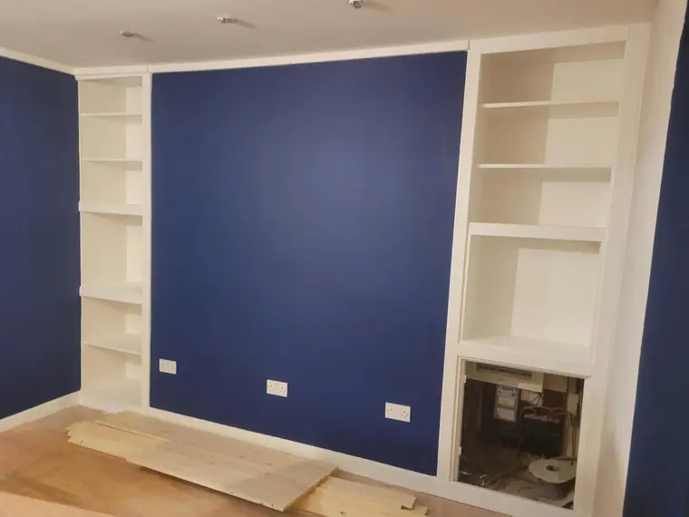Alcove shelving painted out in white either side of the chimney breast.