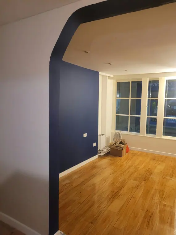 Navy walls and a white arch opening onto the bay window.