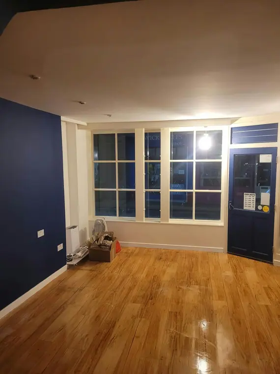 The front room finished: navy walls, white window joinery and a high-gloss floor.