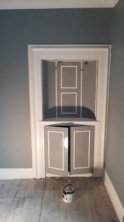 An alcove cupboard with its panel mouldings picked out in white against grey.