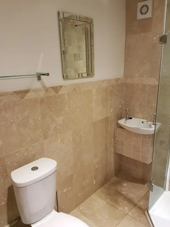 Half-height tiling with a diamond border, finished to a clean line below the mirror.