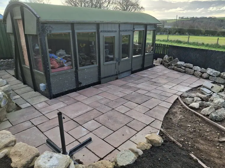 The same sun room after landscaping, with level paving across the frontage