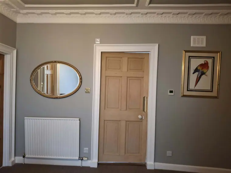 The landing finished: grey walls and crisp white architraves set against the original pine doors.
