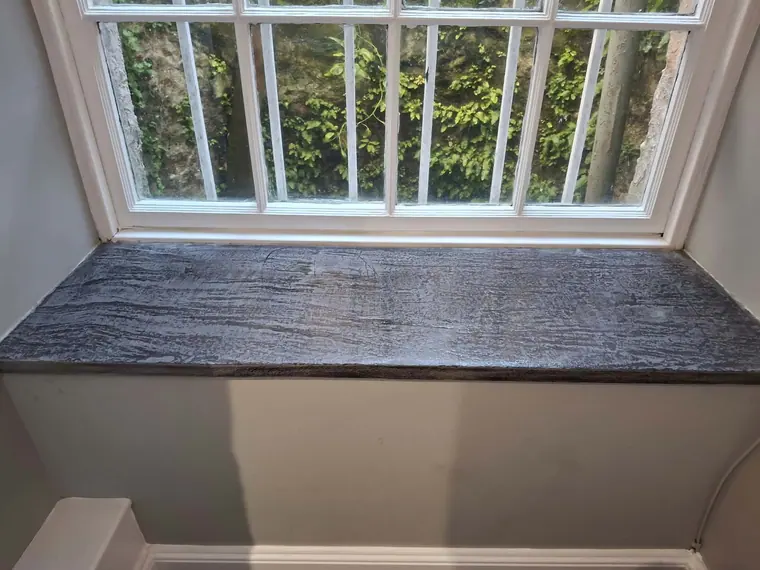 The same window board refinished in a deep, even stain